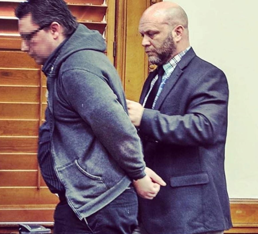 David Lashley controlling an escort inside a courtroom
